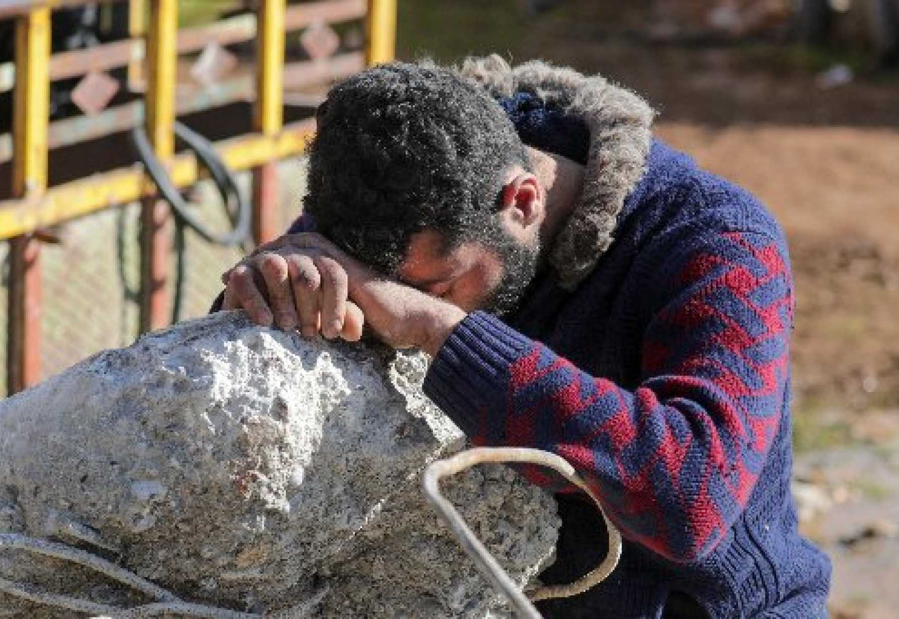 Man prayer over rubble
