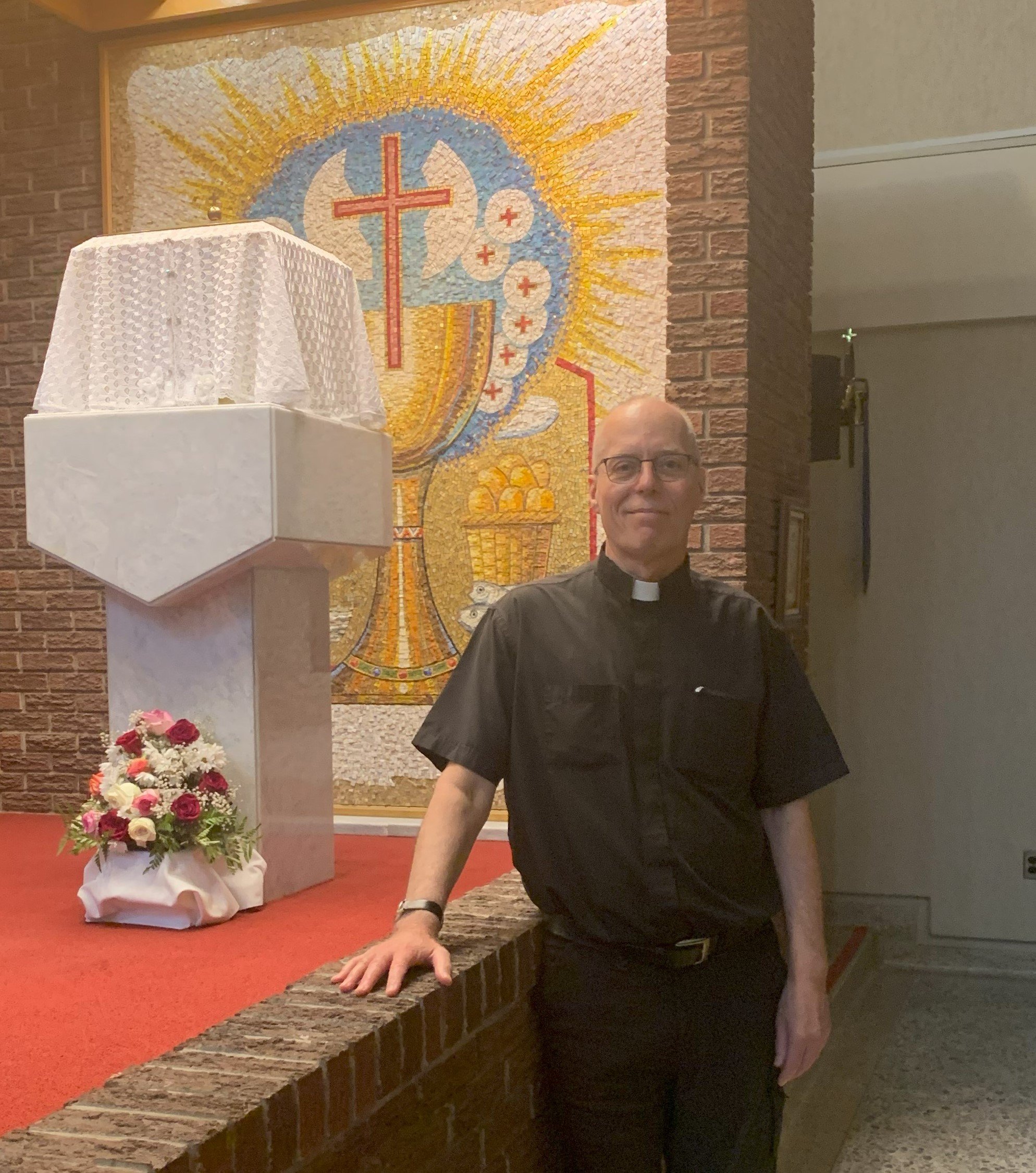 Fr. Peter beside the Blessed Sacrament at St. Mary's